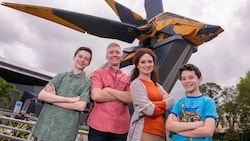 A family of 4 pose for a photo outside of Guardians of the Galaxy Cosmic Rewind