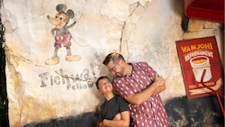 A father and son smiling and standing against a wall at Harambe Market at Disney’s Animal Kingdom theme park