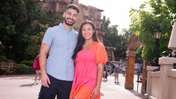 A couple poses for a picture in front of a Mesoamerican pyramid in the Mexico Pavilion at Epcot 