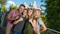 A family of 4 smile on a bridge near Mount Everest