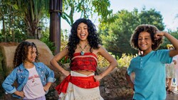 Moana grins and poses with children