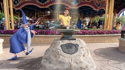 A Disney Magic Shot, featuring Merlin from the film ‘The Sword in the Stone’ waving his wand at a girl trying to remove the sword at this Walt Disney World photo op location