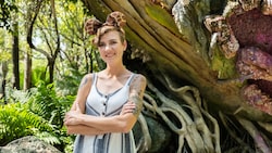 A woman poses in front of a branch from the Tree of Life at Disney’s Animal Kingdom theme park