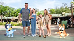 A Disney Magic Shot, featuring Bluey and Bingo, characters from the TV show Bluey, with a couple and their 2 daughters