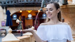 A Disney Magic Shot, featuring Remy from the film Ratatouille on the palm of a woman, near the Remy’s Ratatouille Adventure attraction