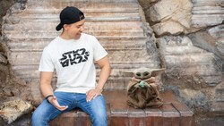 A Disney Magic Shot, featuring Grogu from the film Star Wars, the Mandalorian and Grogu, with a young man at Star Wars, Galaxy’s Edge