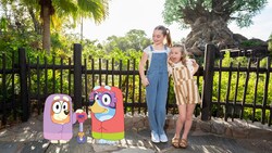 A Disney Magic Shot, featuring Bluey and Bingo, characters from the TV show Bluey, with 2 young girls near the Tree of Life in Disney’s Animal Kingdom theme park