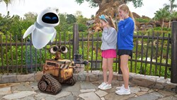 A Disney Magic Shot, featuring Wall E and Eve from the movie Wall E, with 2 girls at the Tree of Life in Disney’s Animal Kingdom theme park