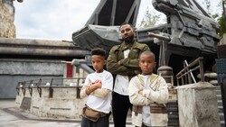 A father and 2 boys posing in front of the ship at First Order Cargo