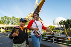 A boy holds a Guardians of the Galaxy Cosmic Rewind cup, and his mom carries an Awesome Mix Tape purse