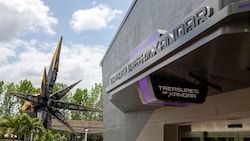 A spaceship sits outside of a large building with a sign saying ‘Treasures of Xandar’