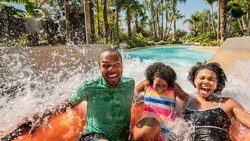 Uma família rindo na atração Miss Adventure Falls