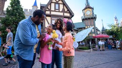 A smiling family of 4 gathered outside Peter Pan’s Flight