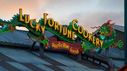 Lit up at night, artistic outdoor signage with a dragon that says, Lucky Fortune Cookery Pacific Rim Foods, located in San Fransokyo Square at Disney California Adventure Park