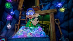 Dopey the Dwarf waves hello from behind a mining car filled with gems in the Snow White’s Enchanted Wish attraction at Disneyland Park in California