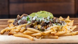 Fries topped with carne asada, cheese, cilantro, onions and guacamole