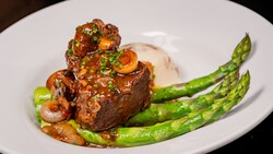 Red Wine Braised Beef Short Rib topped with onions and mushrooms and served with mashed potatoes and asparagus