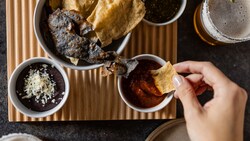 Totopos con frijoles refritos y un surtido de salsas