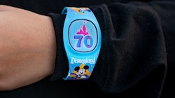 A Guest wearing a Disneyland Resort 70th Celebration Magic Band Plus