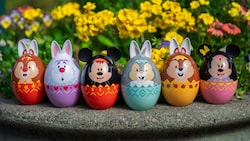 Easter eggs decorated like Disney Characters sit on a ledge surrounded by flowers