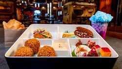 A bento box with assorted Star Wars themed appetizers including Fried Cheeseburger Croquette Bites, Apricot Goat Cheese, Dragon Fruit Yogurt and more