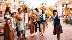 A group of Guests listening to a Cast Member during Disney’s Happiest Haunts Guided Tour at Disneyland Park