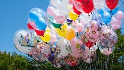 A cluster of Disney Princess balloons and clear balloons with Mickey icon balloons inside  
