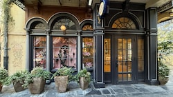 The façade of Mademoiselle Antoinette's Parfumerie with large windows displaying fragrance bottles, floral arrangements and a mannequin