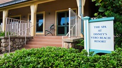 A sign that says The Spa at Disney’s Vero Beach Resort next to stairs leading to the front of a building