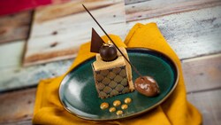 A dessert featuring chocolate mousse, a chocolate truffle and decorative chocolate pieces