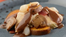 Sliced turkey and mushrooms topped with a cream sauce, served over sliced sweet potatoes
