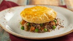 A serving of the jackfruit pot pie, featuring jackfruit, peas and carrots topped with a puff pastry