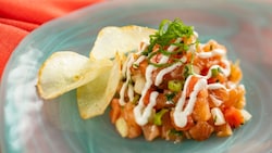 A serving of lomi lomi salmon, featuring diced raw salmon, onions and yucca chips