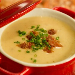 A bowl of cheddar soup topped with bacon crumbles 