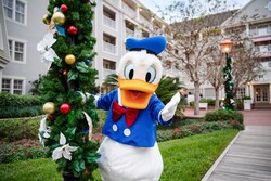 Donald Duck posing next to a lamp post with holiday garland at Disney's Yacht Club Resort