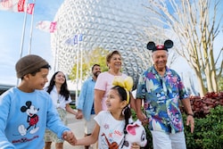 A multigenerational family walking in front of Spaceship Earth at Epcot