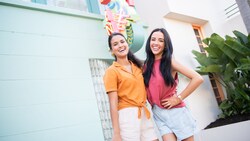 Two women laugh while standing outside of 50’s Prime Time Café at Disney’s Hollywood Studios