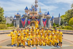 Players from the Savannah Bananas posing in front of Sleeping Beauty Castle at Disneyland Park