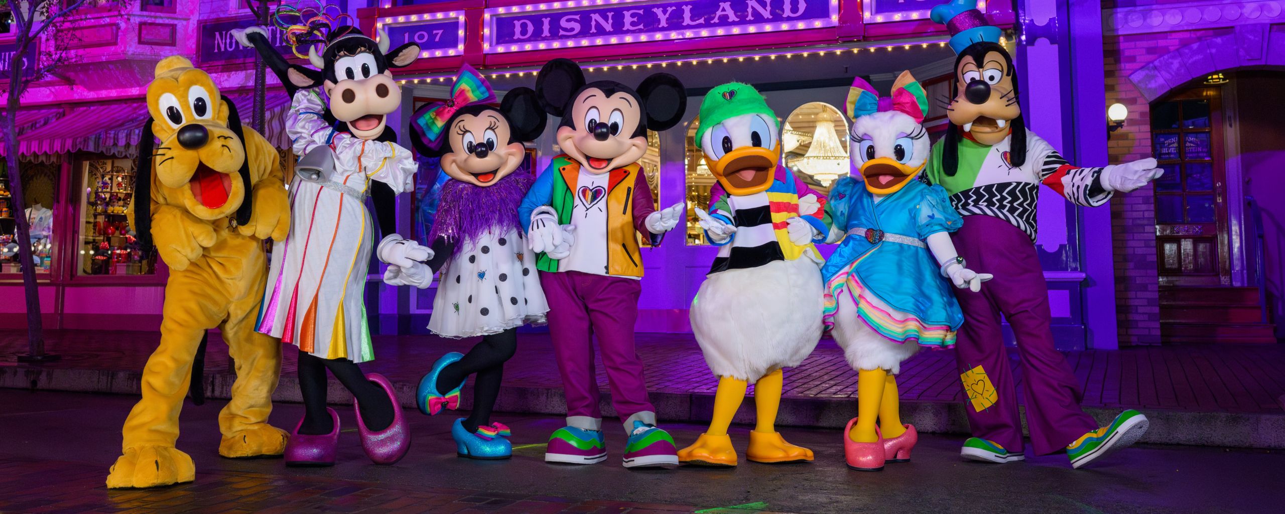 Pluto, Clarabelle Cow, Minnie Mouse, Mickey Mouse, Donald Duck, Daisy Duck and Goofy posing for a picture in front of Crystal Arcade in Disneyland Park