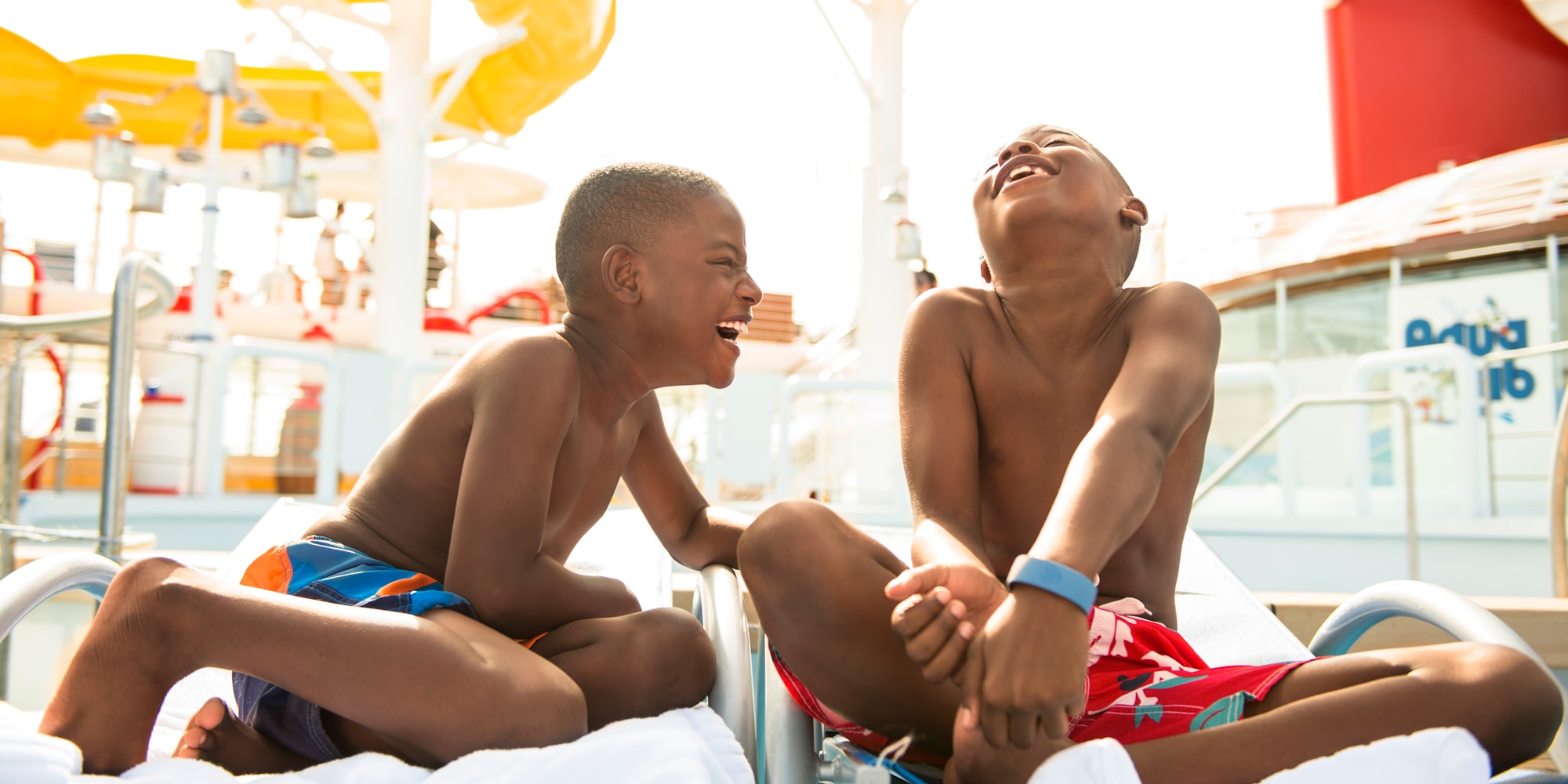 Two boys laughing and enjoying the pool on deck
