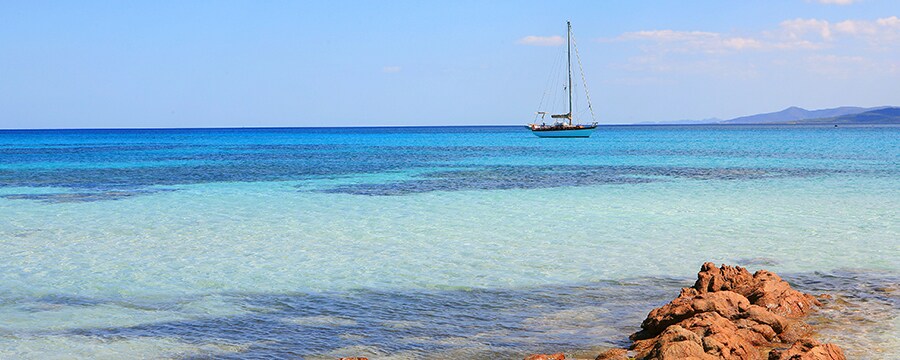 A sailboat floating over clear ocean waters