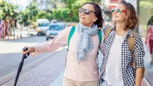Una mujer con una caña y una joven que mira sonriente