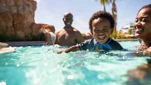 Mom and dad swim with toddler in Disney's Riviera Resort pool