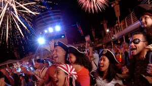 Una audiencia vestida de Personajes de Pirates of the Caribbean se maravilla con los fuegos artificiales en altamar