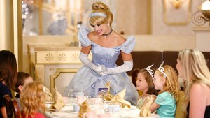 Princess Cinderella greets little girls in tiaras at a fancy luncheon