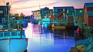 Fishing boats next to docks in a canal lined by houses