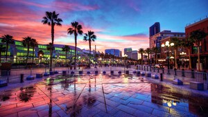 Palm trees and parking barricades in front of a modern looking shopping area at sunset