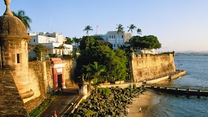 Stone walls separate a beach from buildings