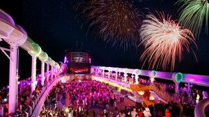 Fireworks bursting over the swimming pool area of a Disney Cruise Line ship during a night time deck party