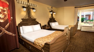 Una habitación con temática de piratas en Disney's Caribbean Beach Resort incluye camas en forma de barco y una bandera del Jolly Roger